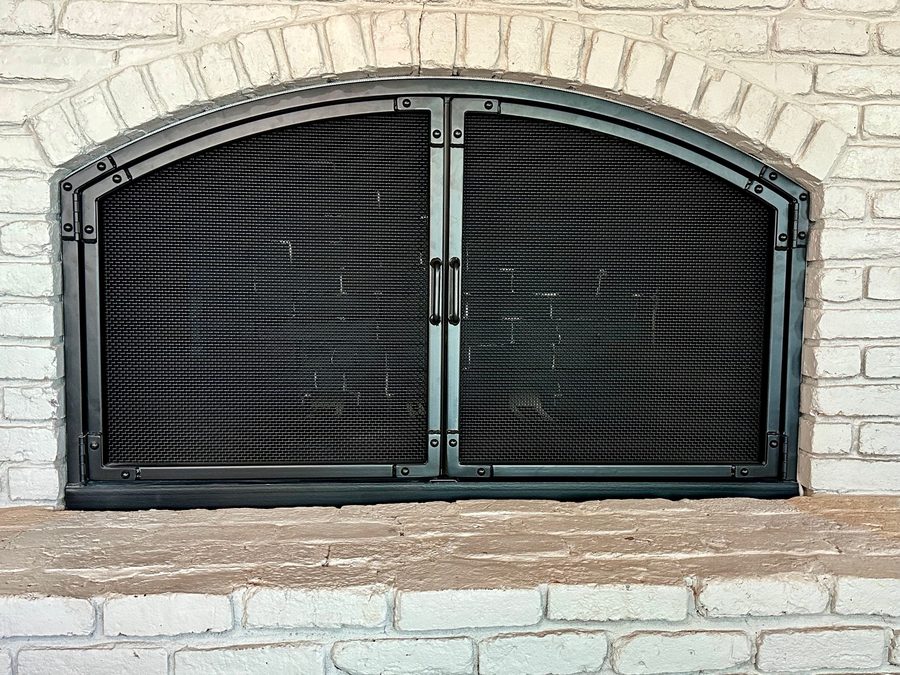 A robust arched metal frame with riveted detailing and fine mesh panels, combining durability with a sleek, modern look.