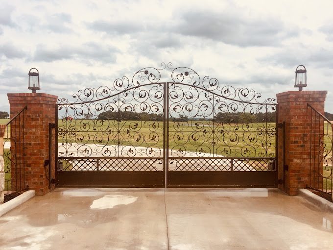 The elegant Iron scrollwork perfectly complements the brick pillars and open landscape.