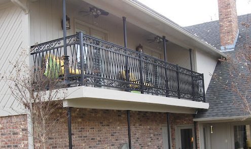 The balcony railing features intricate wrought iron scrollwork with elegant geometric accents.