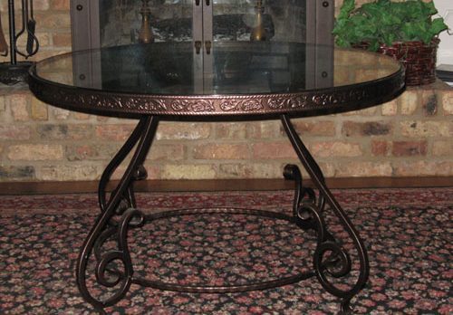 Attractive Table with copper colored finish and delicate engraving around the rim.